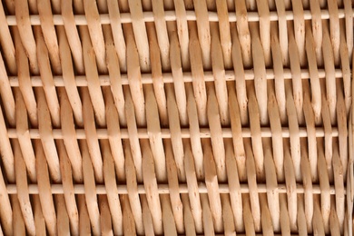 Handmade wicker basket made of natural material as background, closeup view