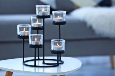 Burning candles on table against blurred background