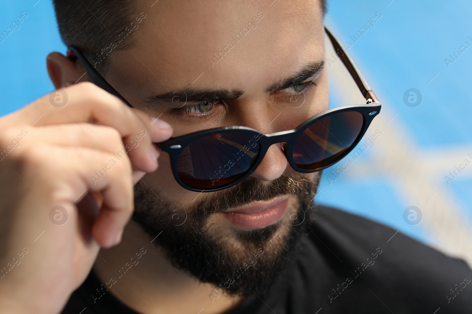 Photo of Handsome man in sunglasses outdoors on sunny day, closeup