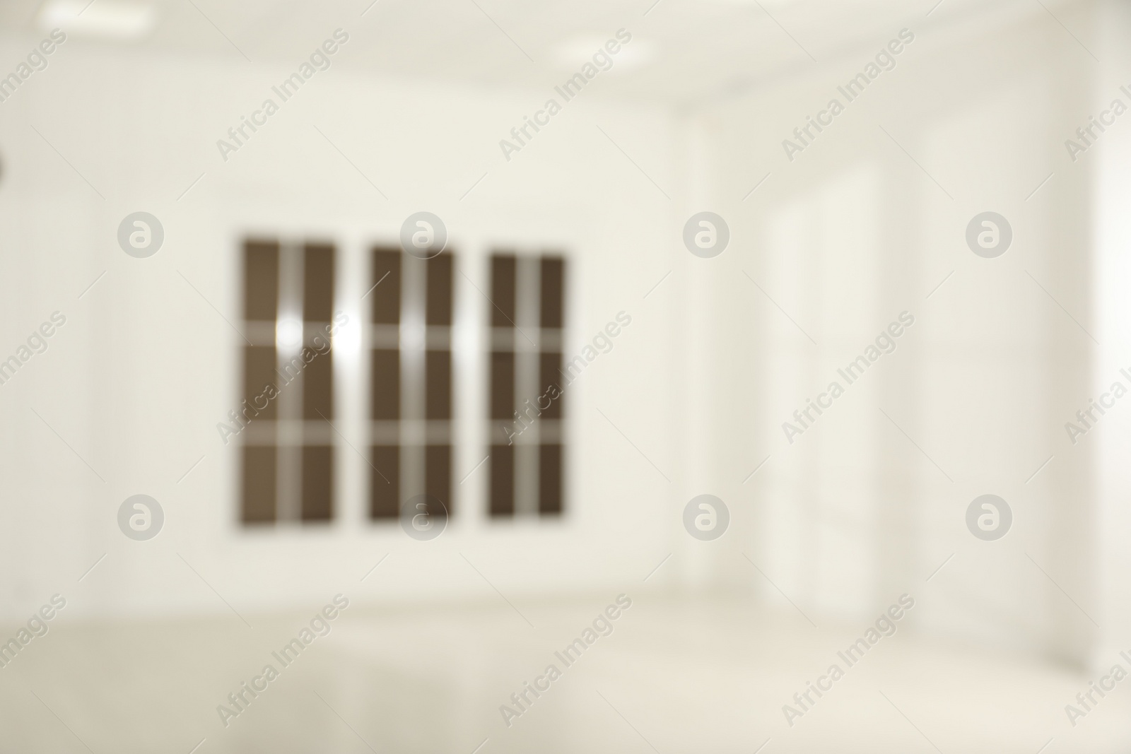 Photo of Empty room with white walls and large window, blurred view