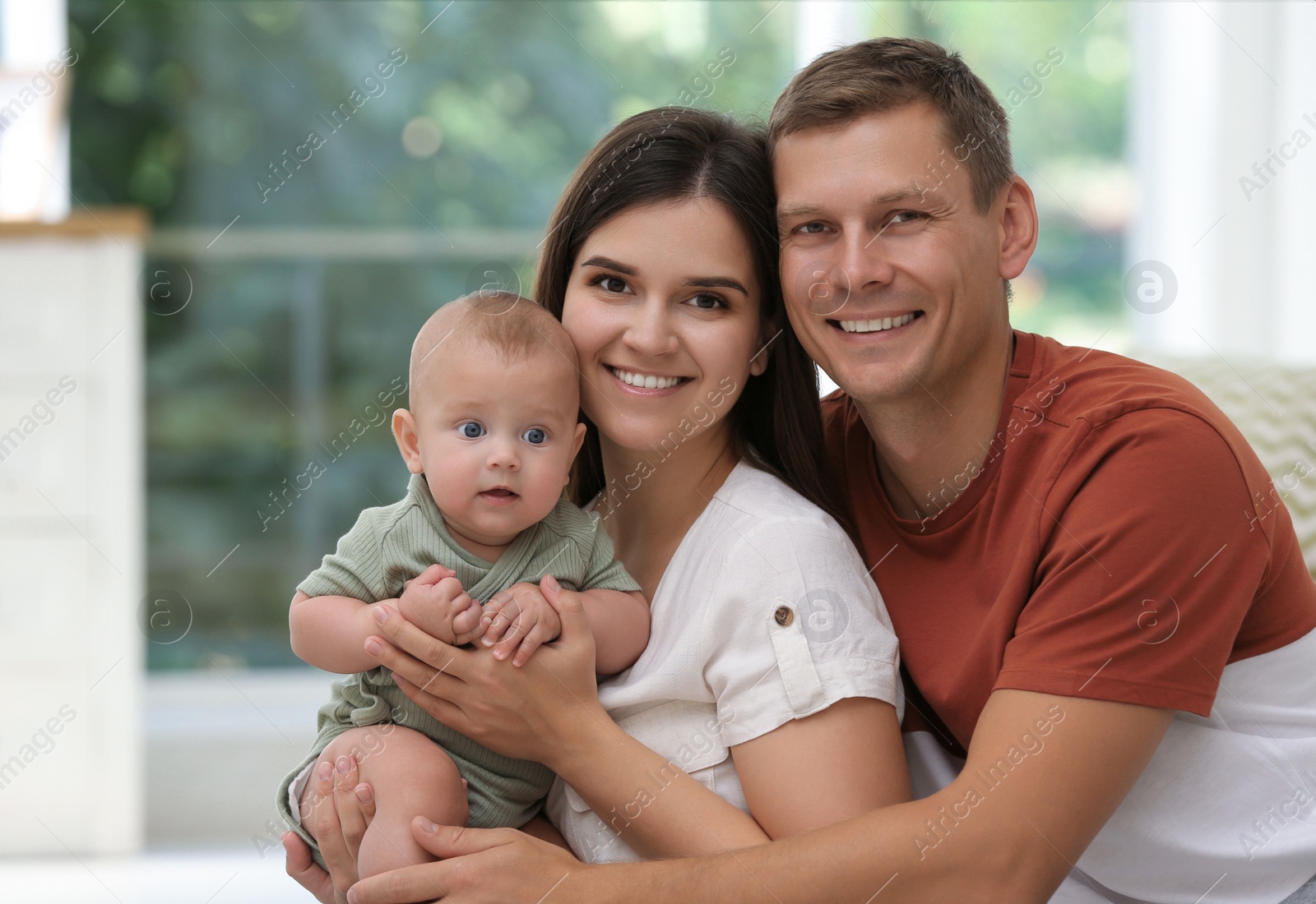 Photo of Portrait of happy family with their cute baby at home