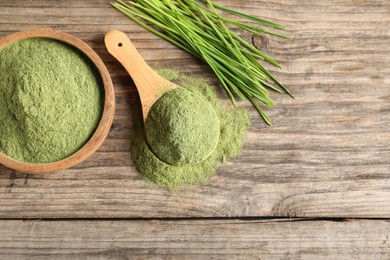 Photo of Wheat grass powder and fresh sprouts on wooden table, flat lay. Space for text