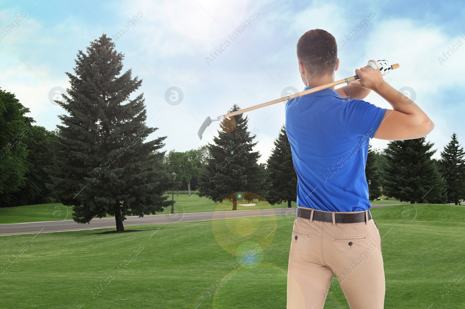 Image of Young man playing golf on course with green grass, back view. Space for design