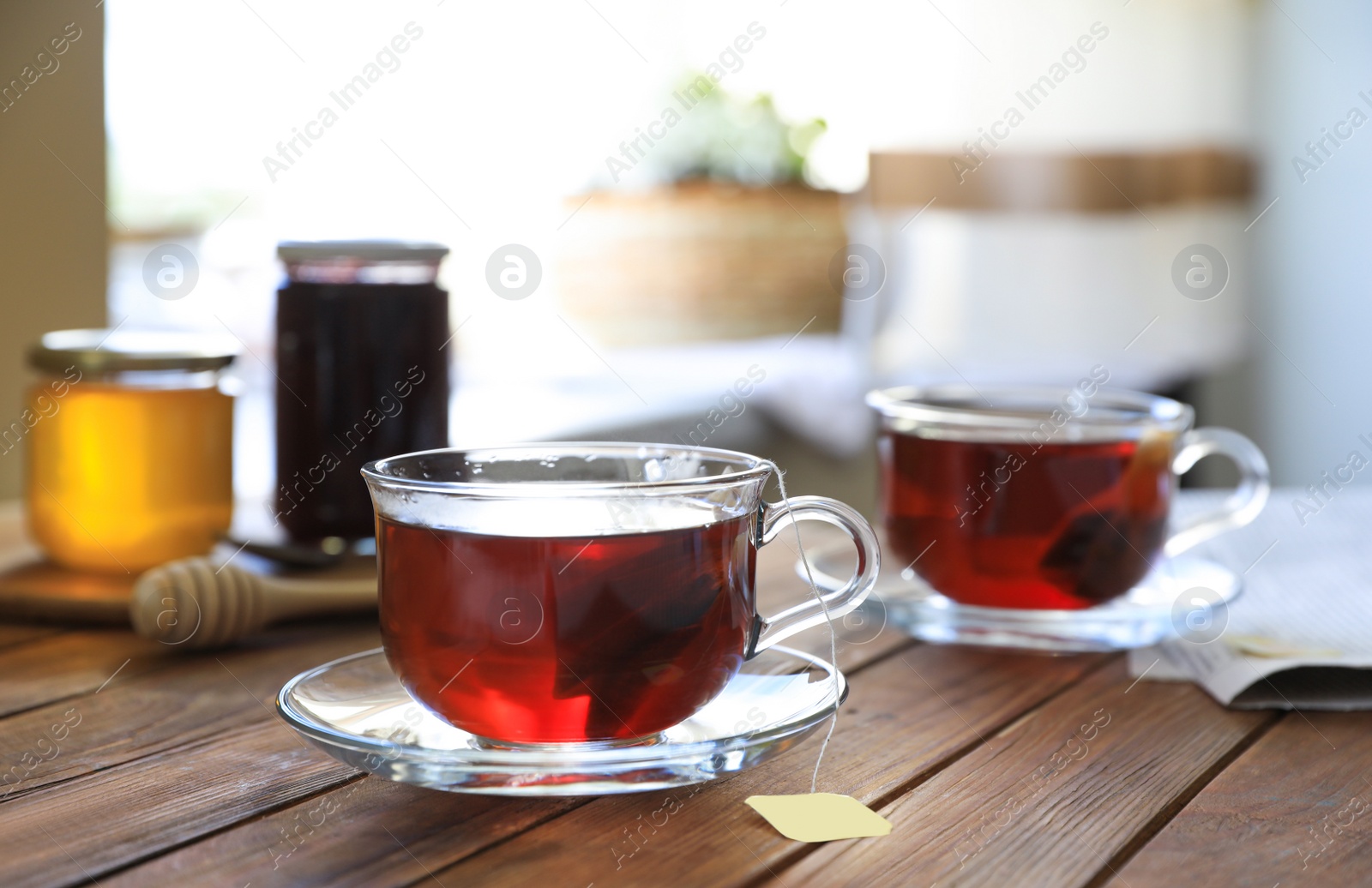 Photo of Tea bag in glass cup on wooden table indoors