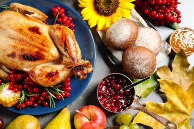 Photo of Flat lay composition with delicious turkey on grey background. Happy Thanksgiving day