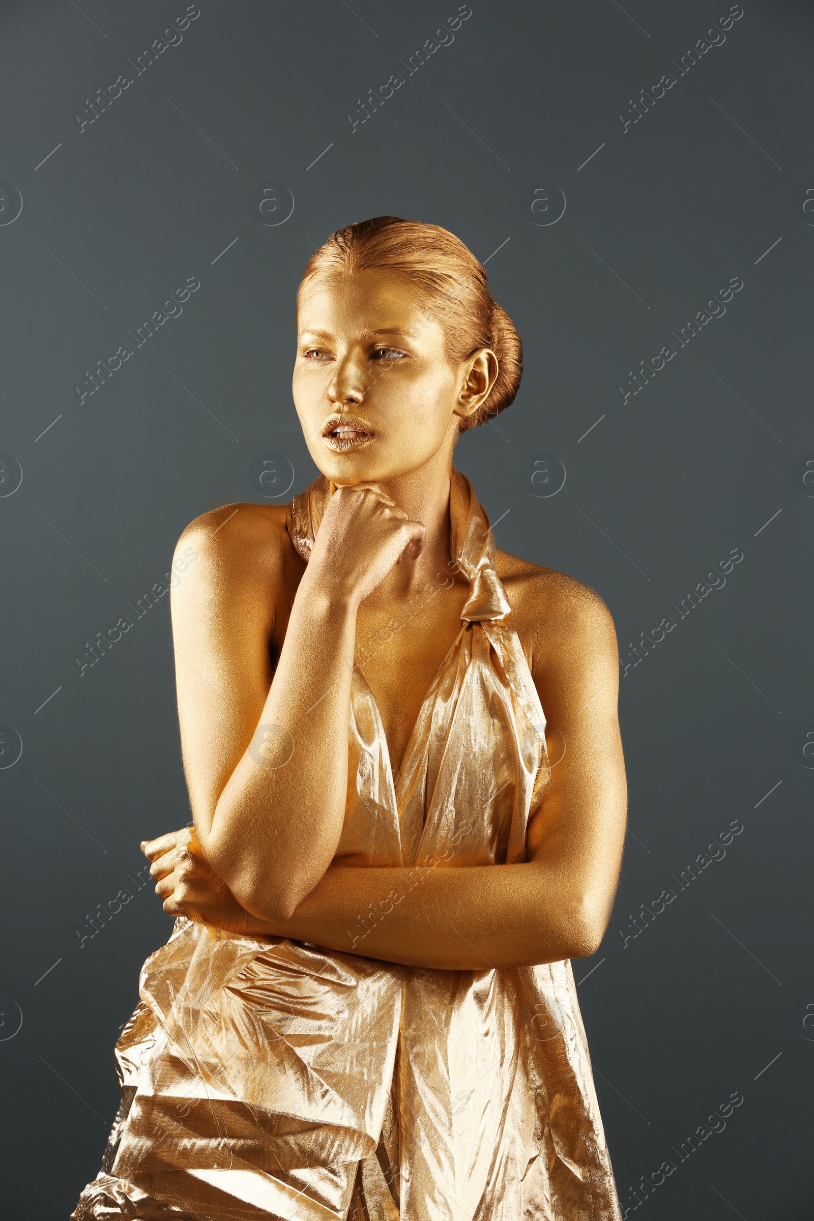 Photo of Portrait of beautiful lady with gold paint on skin against grey background