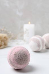 Pink bath bomb on white table, space for text