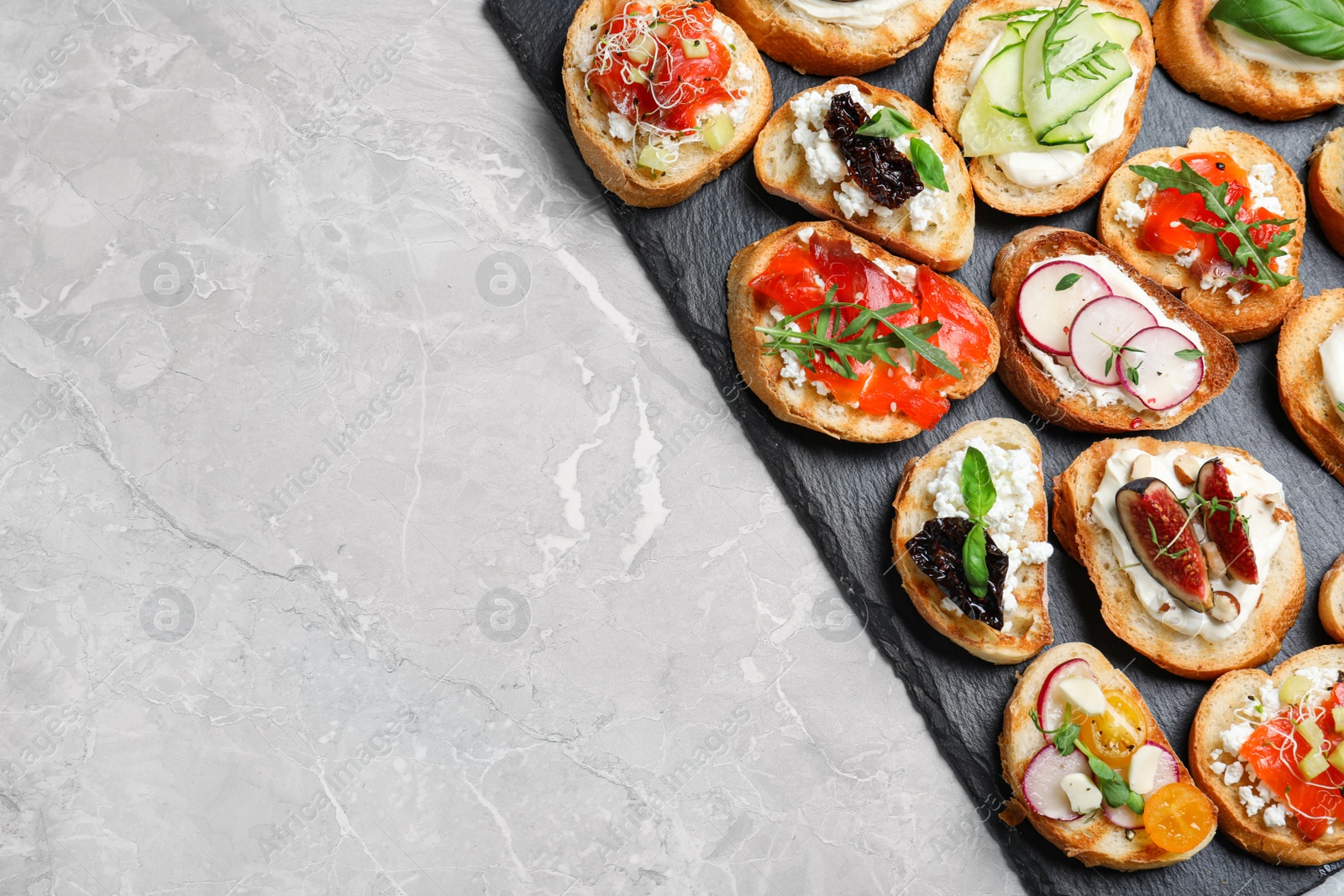 Photo of Different bruschettas on light grey marble table, top view. Space for text