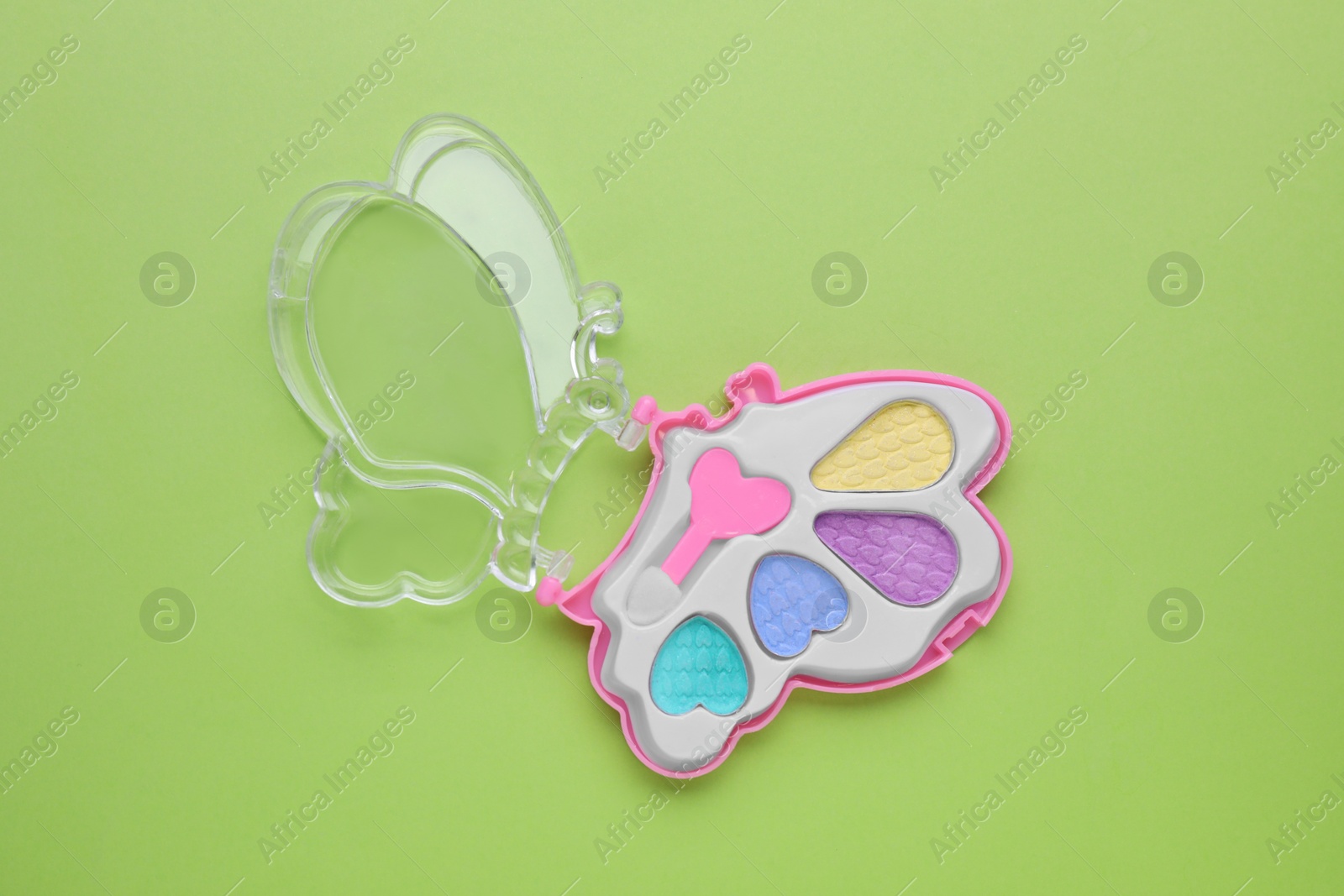 Photo of Decorative cosmetics for kids. Eye shadow palette on light green background, top view