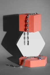 Photo of Elegant jewelry. Stylish presentation of luxury bracelets and ring on podiums against gray background