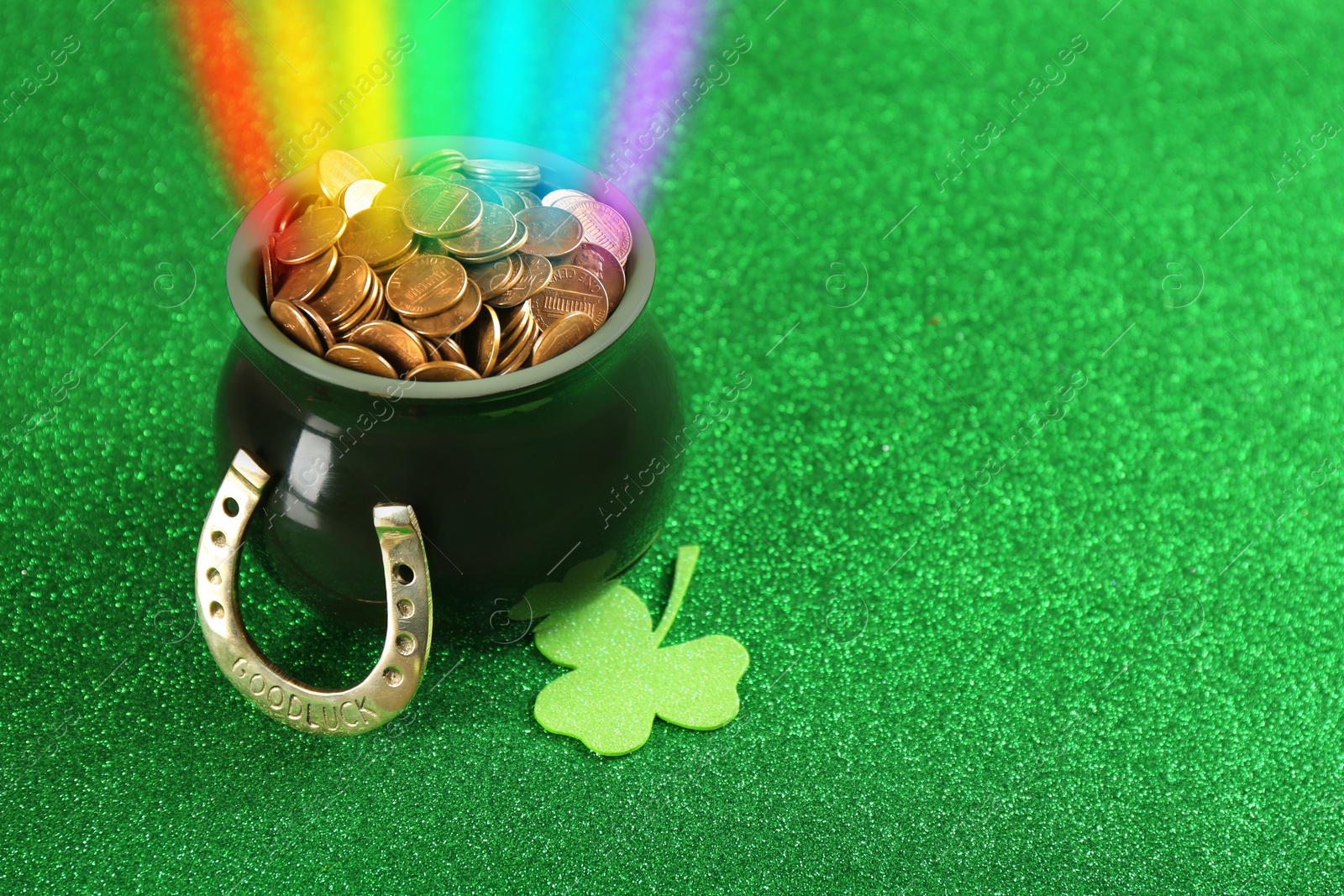 Image of Pot with gold coins, horseshoe and clover on green background, space for text. St. Patrick's Day celebration