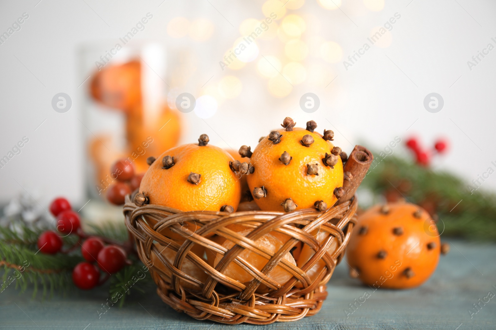 Photo of Pomander balls made of fresh tangerines and cloves on wooden table, closeup