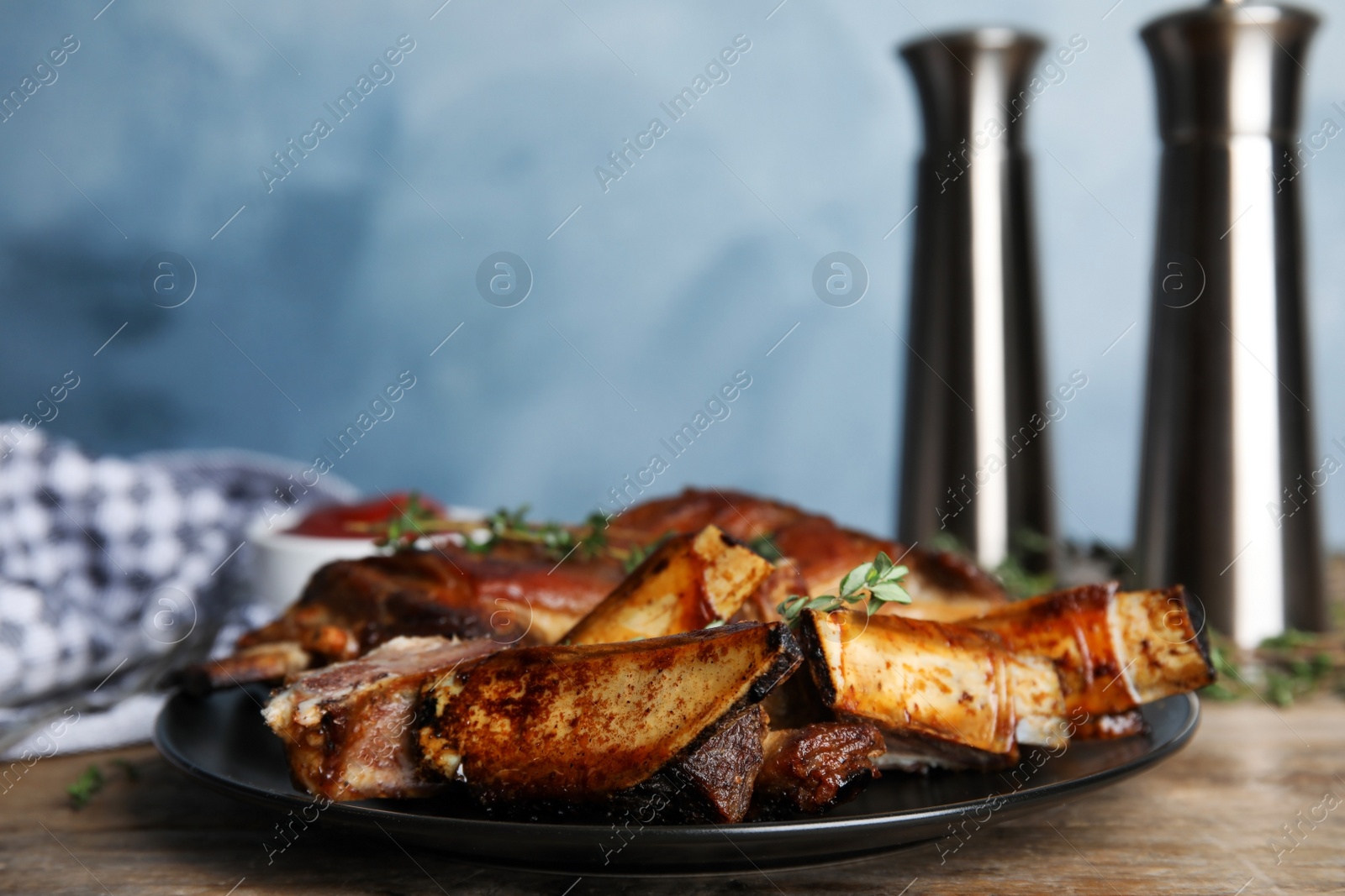 Photo of Delicious roasted ribs served on wooden table