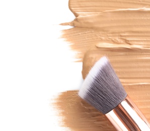 Liquid foundation and brush on white background, top view. Makeup products