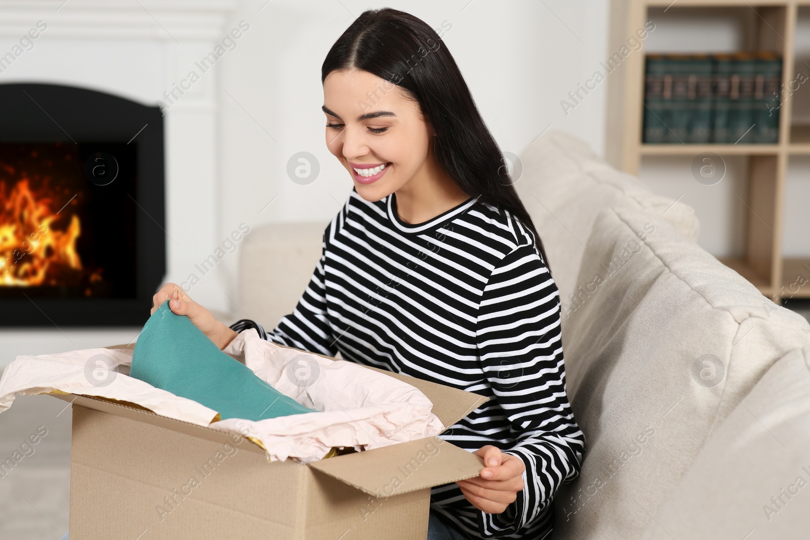 Photo of Happy young woman with parcel at home. Internet shopping