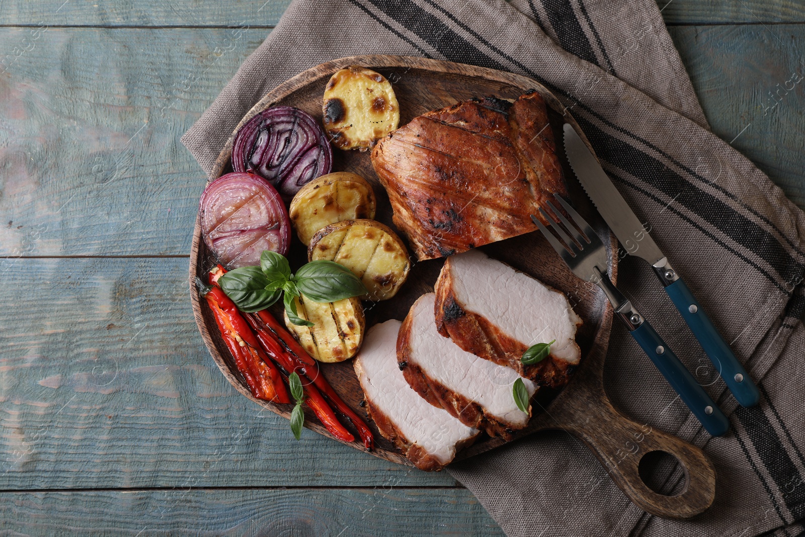 Photo of Delicious grilled meat and vegetables served on wooden table, top view