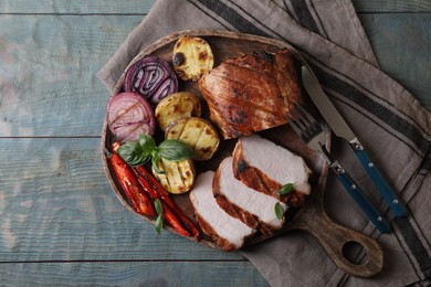 Delicious grilled meat and vegetables served on wooden table, top view