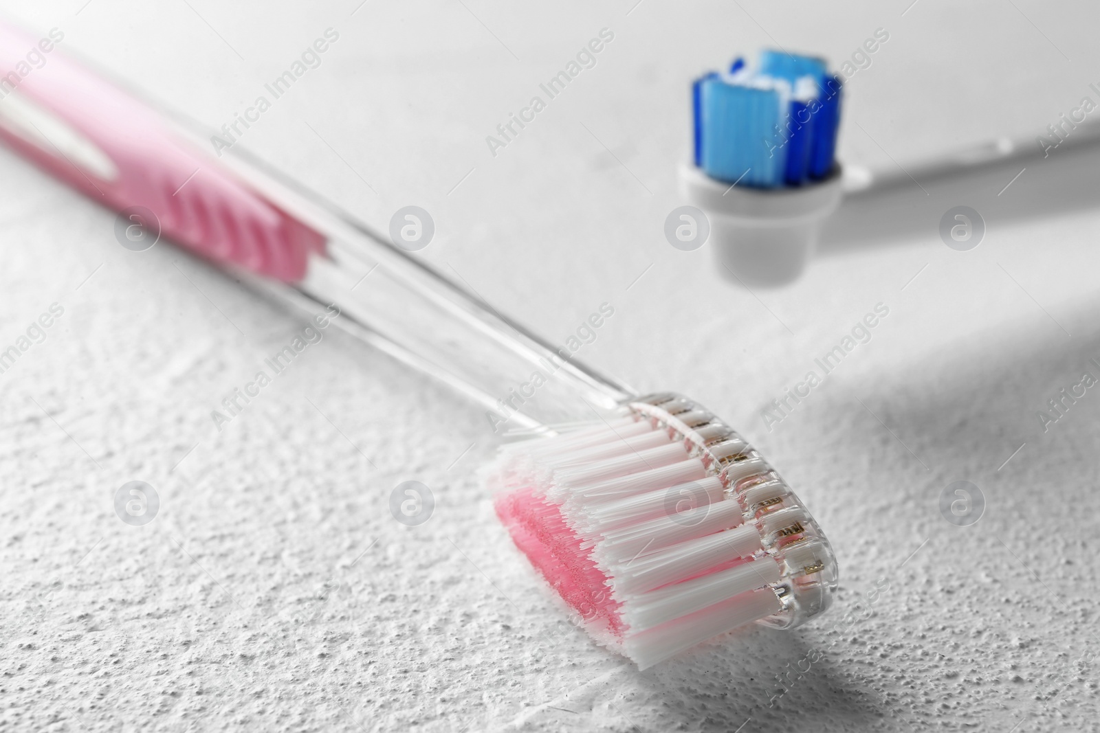 Photo of Electric and manual toothbrushes on light background, close up