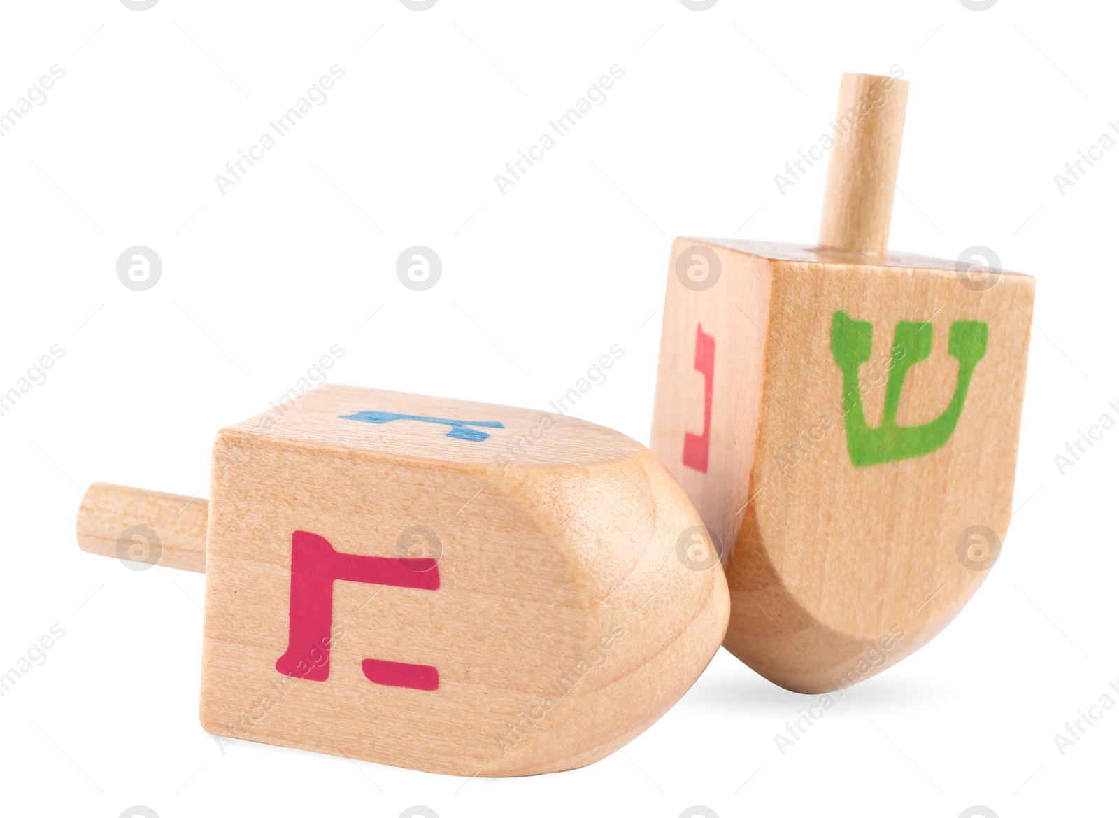 Photo of Hanukkah celebration. Wooden dreidels with jewish letters isolated on white