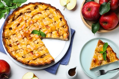 Photo of Traditional apple pie and fresh fruits on white wooden table, flat lay