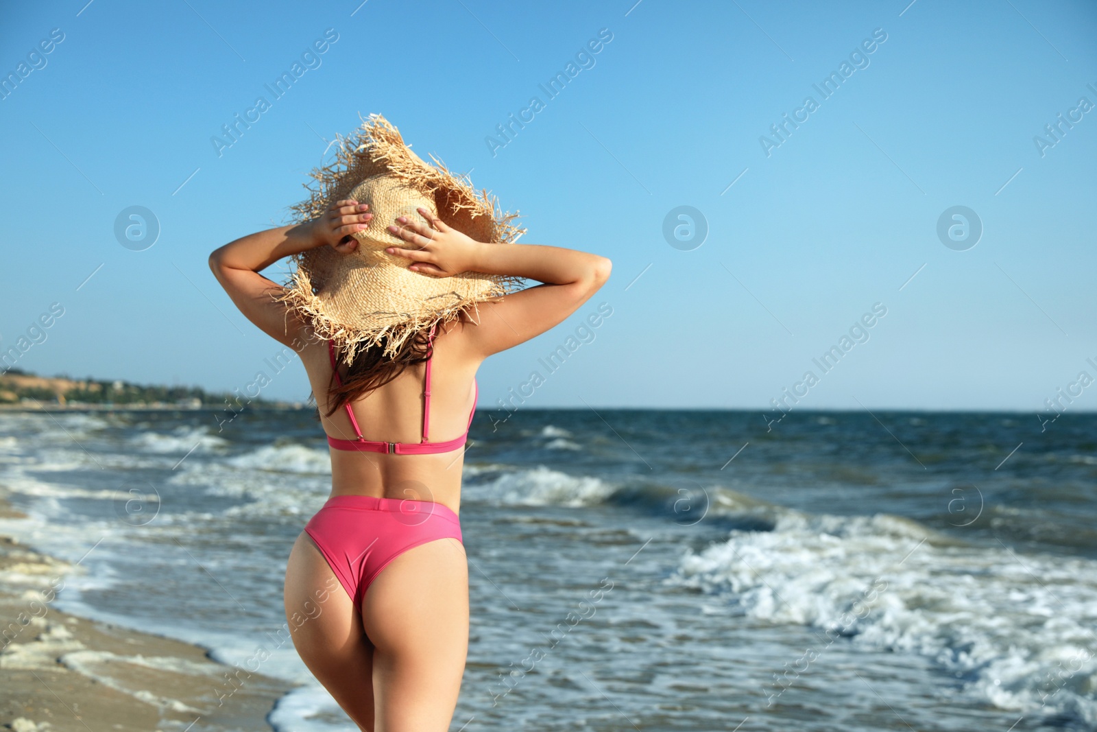 Photo of Young woman with attractive body on beach, back view. Space for text