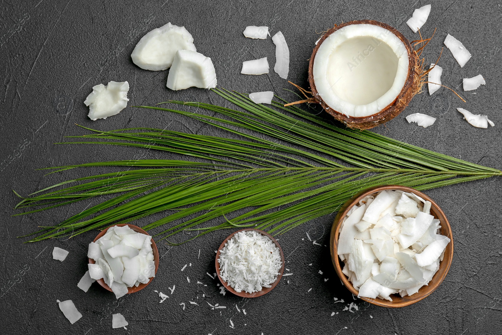 Photo of Composition with fresh coconut flakes on dark background