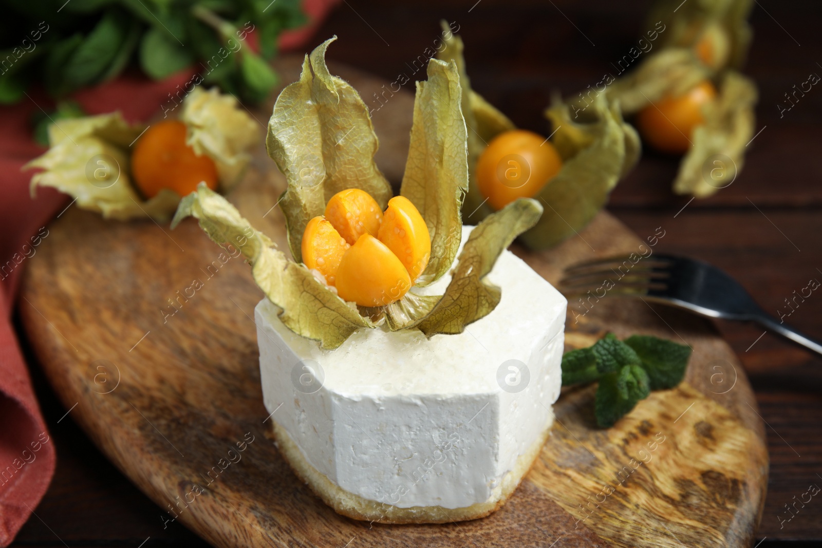 Photo of Delicious dessert decorated with physalis fruit on wooden table