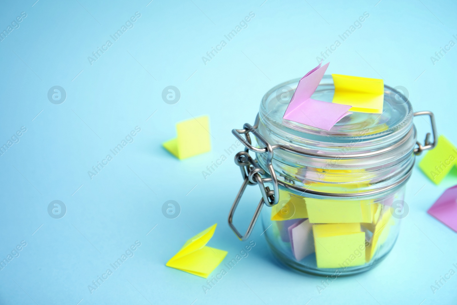 Photo of Glass jar and paper pieces for lottery on color background. Space for text