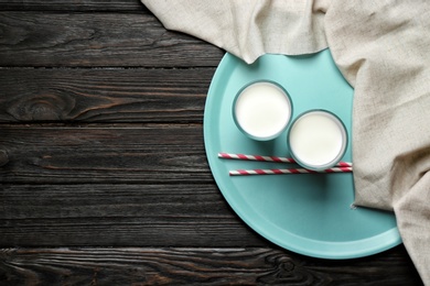 Photo of Glasses with milk on wooden background