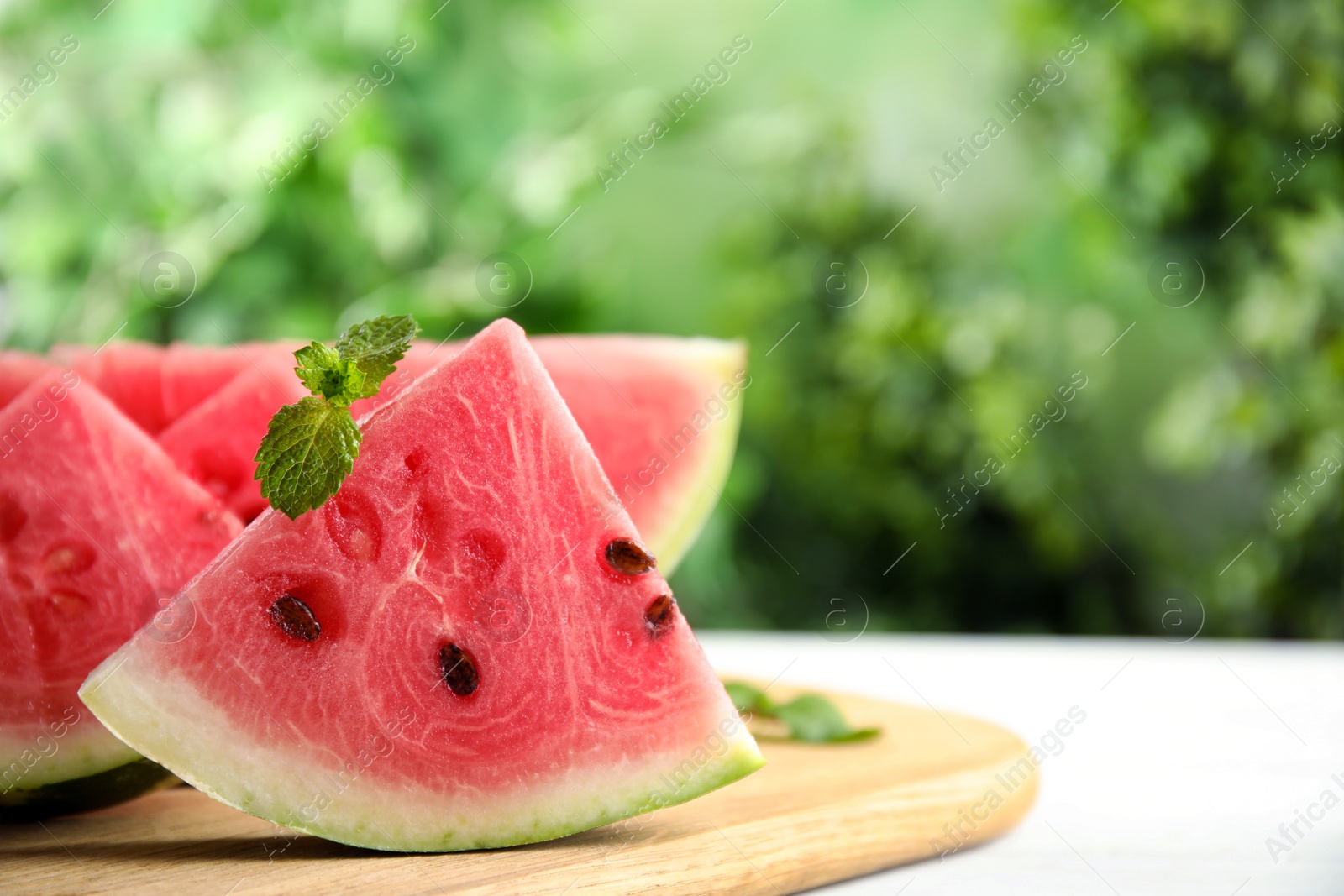 Photo of Slices of ripe juicy watermelon on wooden board, closeup