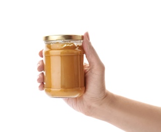 Woman holding jar with creamy peanut butter on white background