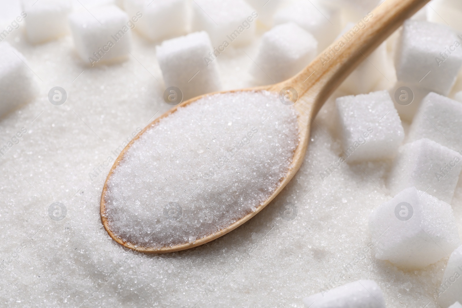 Photo of Different types of white sugar and spoon as background, closeup