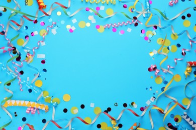Photo of Frame made with carnival items on light blue background, flat lay. Space for text