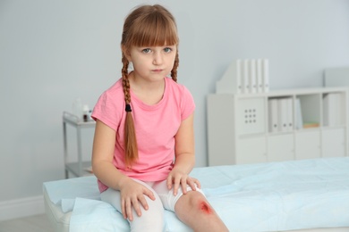 Little girl with injured leg in clinic. First aid