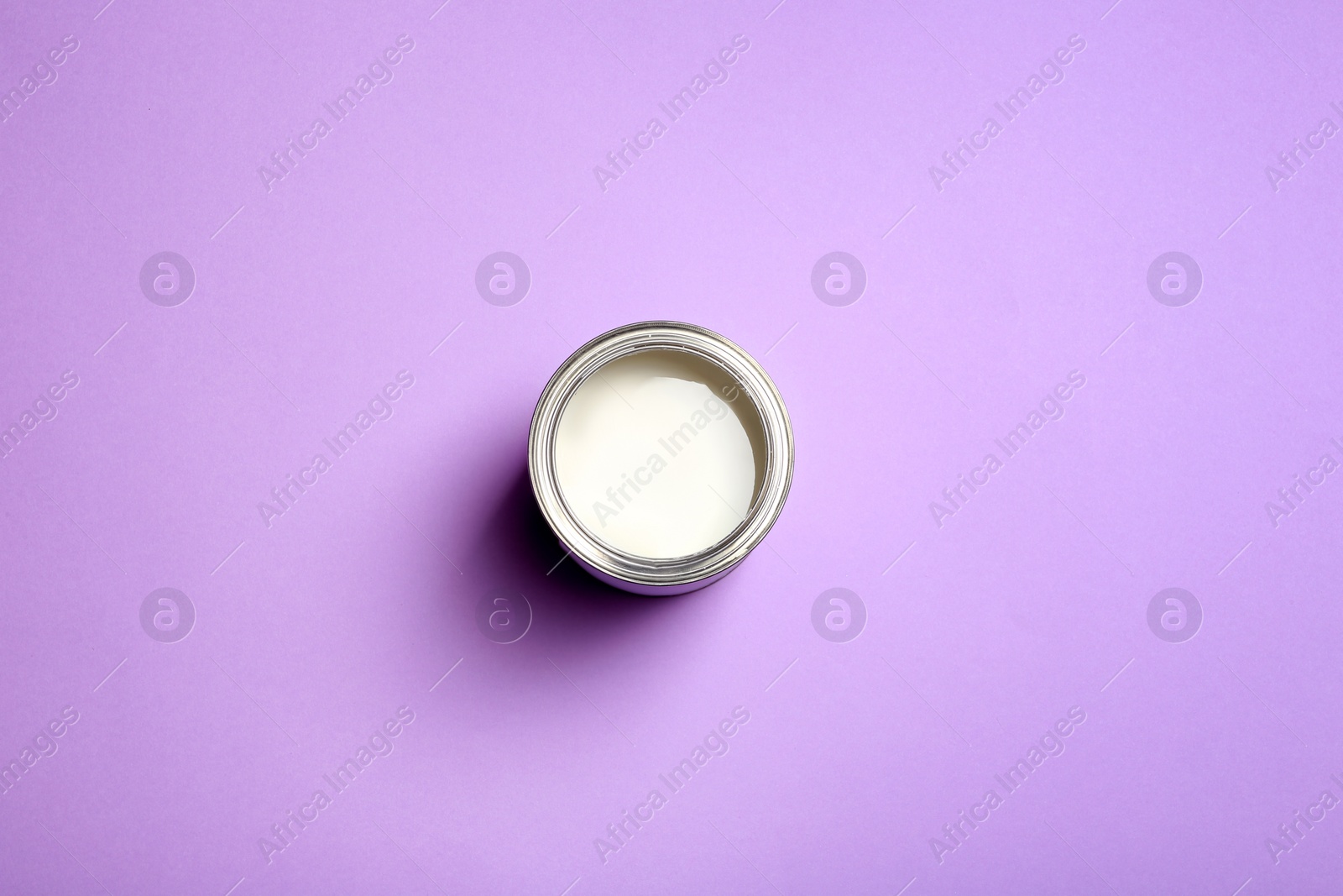 Photo of Open paint can on color background, top view