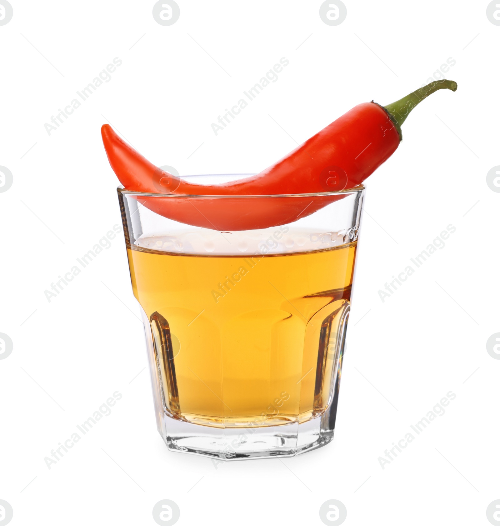 Photo of Red hot chili pepper and vodka in glass on white background