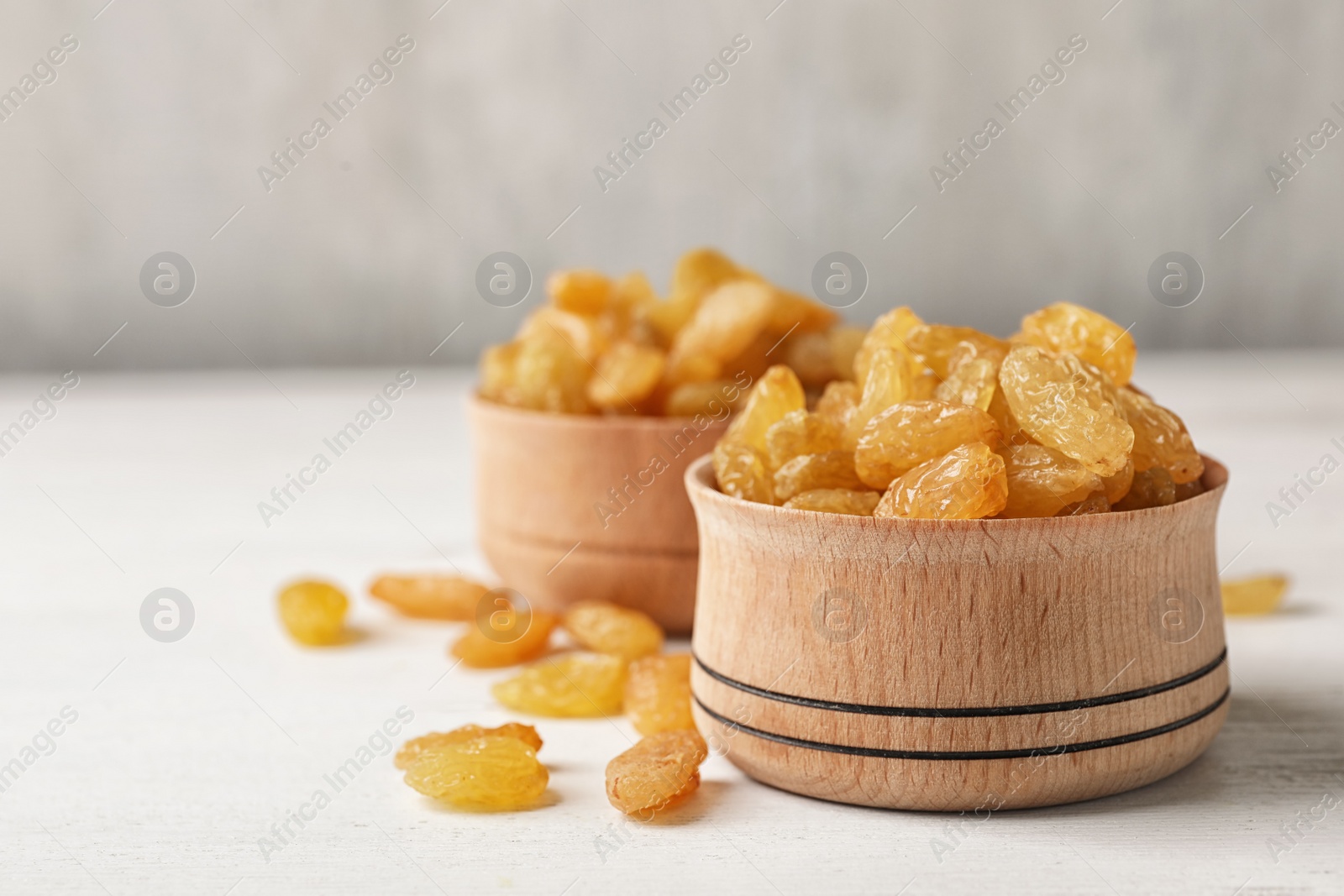 Photo of Bowl with raisins on table, space for text. Dried fruit as healthy snack