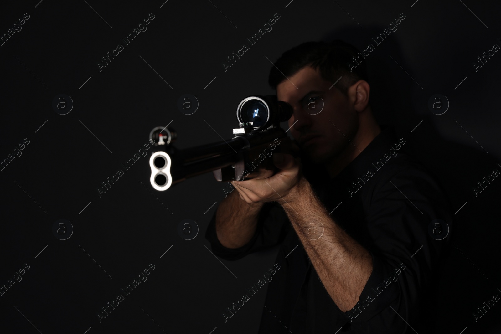Photo of Professional killer with sniper rifle on black background