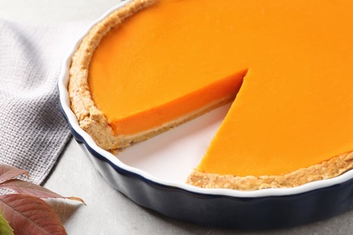 Baking dish with fresh delicious homemade pumpkin pie on gray table