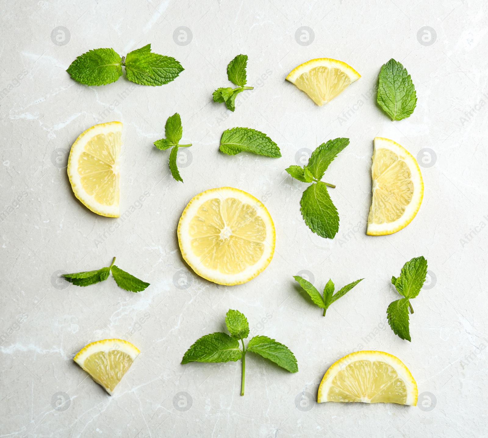 Photo of Fresh mint with sliced lemon on grey marble background, flat lay