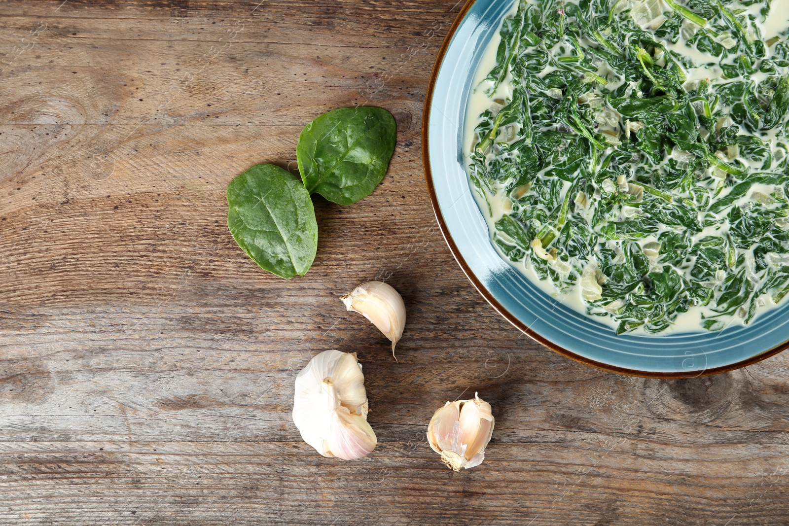 Photo of Tasty spinach dip on wooden table, flat lay