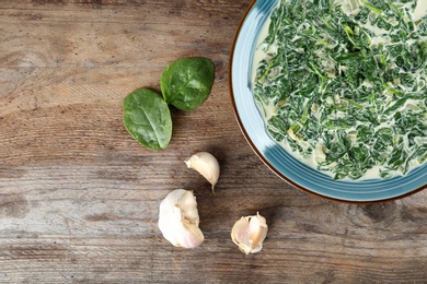 Photo of Tasty spinach dip on wooden table, flat lay