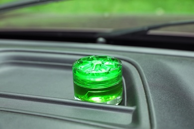 Photo of Stylish air freshener on dashboard in car