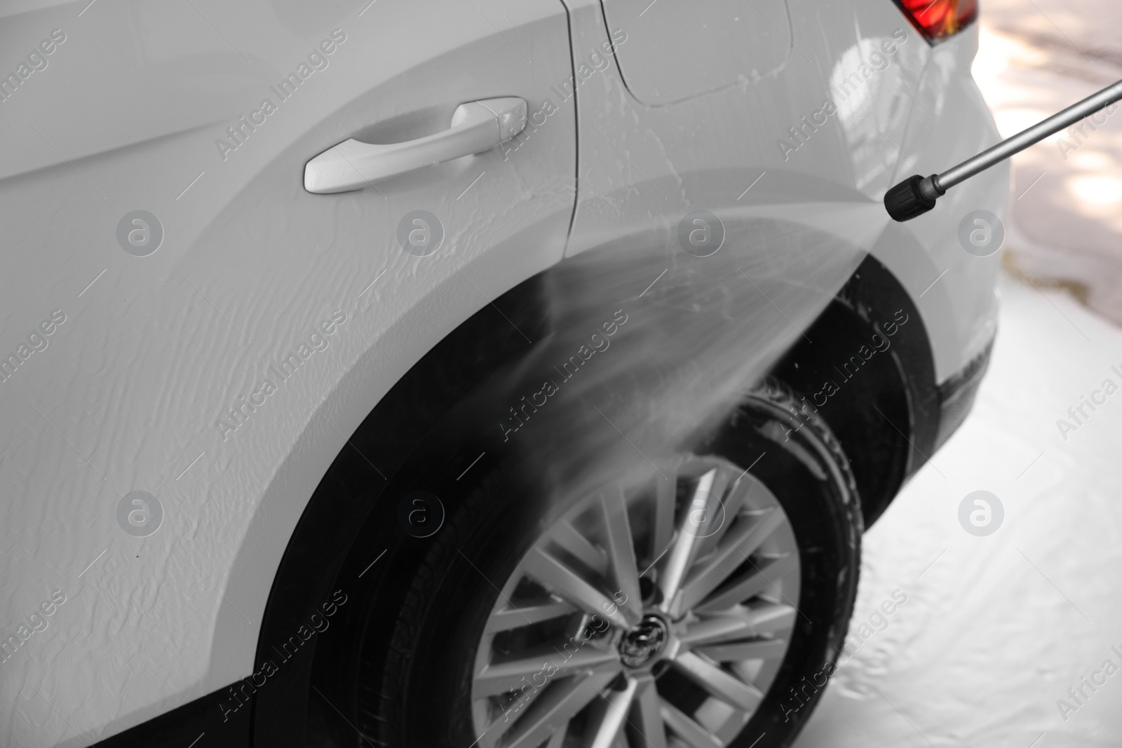 Photo of Washing auto with high pressure water jet at outdoor car wash, closeup