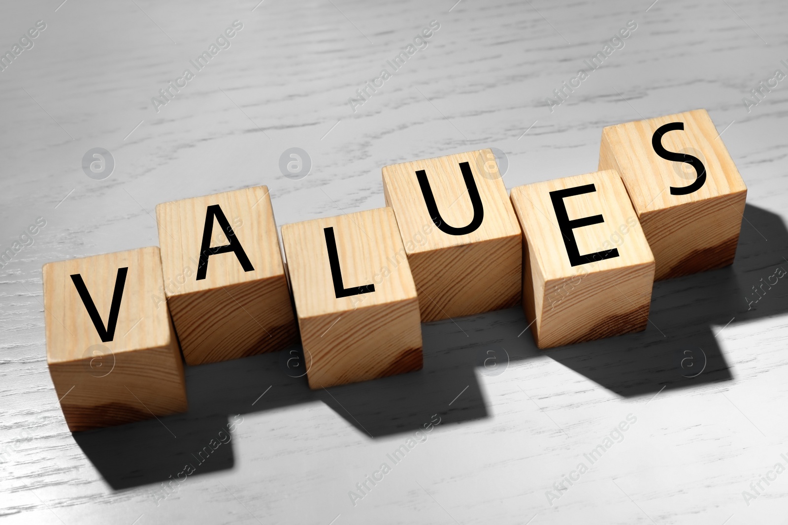 Photo of Cubes with word VALUES on white wooden background