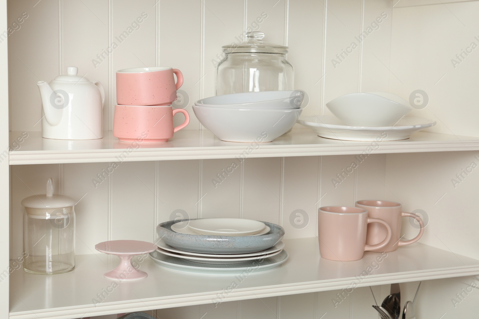 Photo of White shelving unit with set of dishware