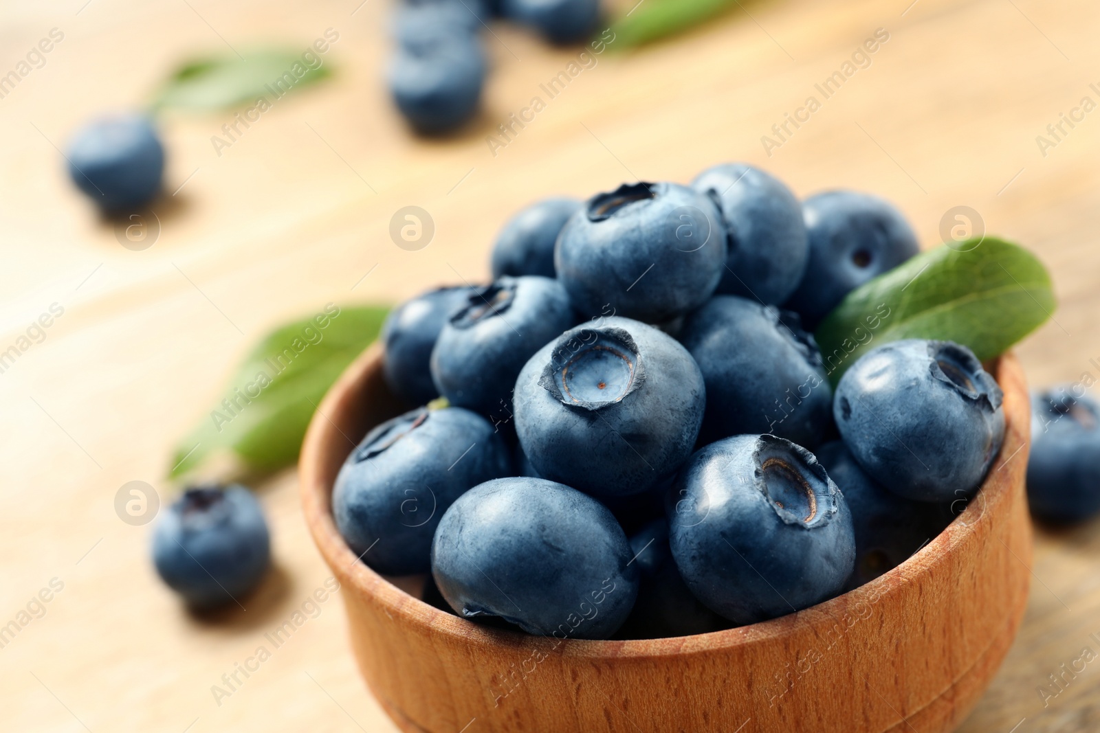 Photo of Bowl of fresh tasty blueberries on table, closeup. Space for text