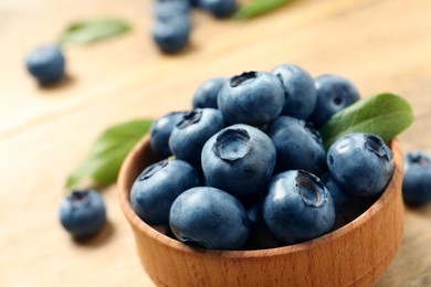 Bowl of fresh tasty blueberries on table, closeup. Space for text