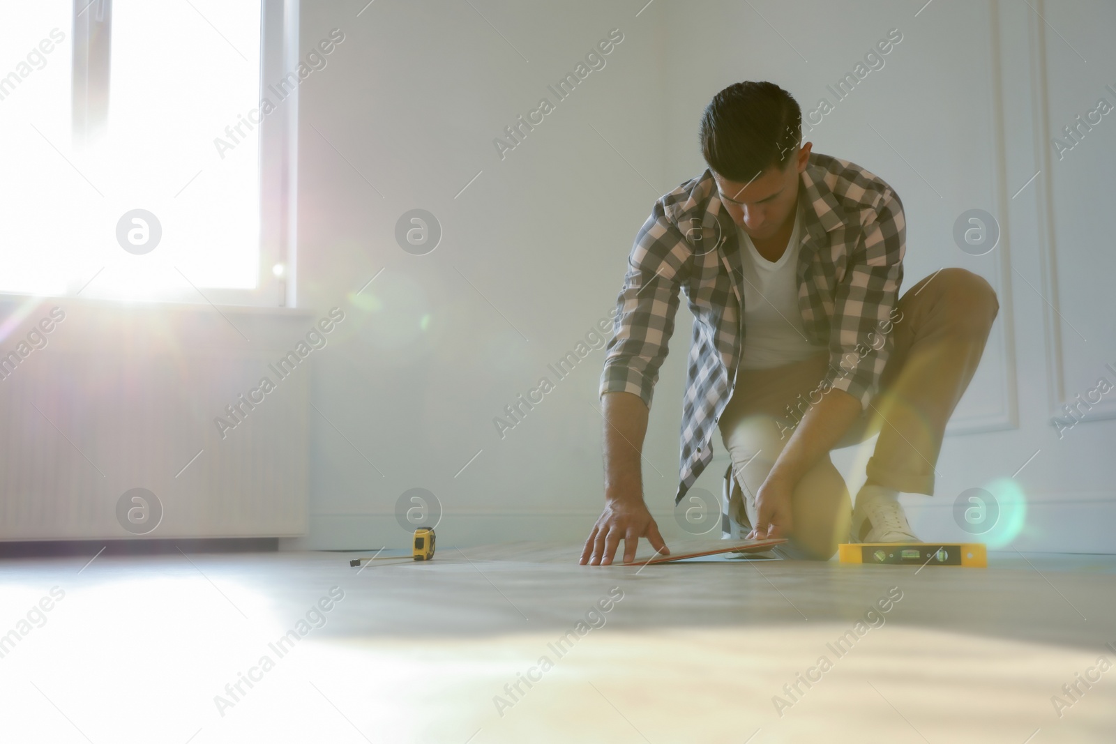 Photo of Professional worker installing new parquet flooring indoors