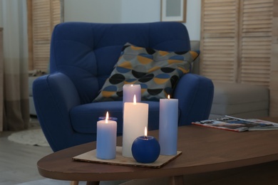 Photo of Burning candles on table in living room